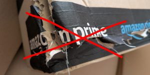 Eine beschädigte Ecke eines Paketes mit einem Klebeband von Amazon Prime ist rot durchgestrichen.
