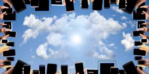 Viele Hände recken mit einem Smartphone in der Hand zum Himmel.