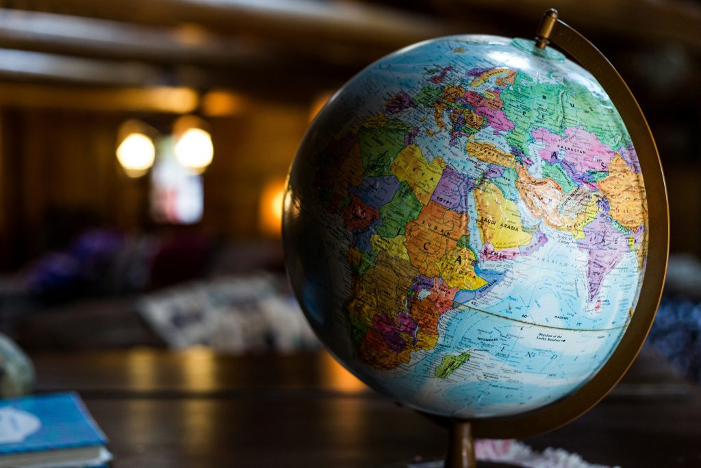 Ein Globus mit politischer Weltkarte in warm beleuchteter Innenraum-Atmosphäre. Europa, Afrika und Asien sind deutlich sichtbar.