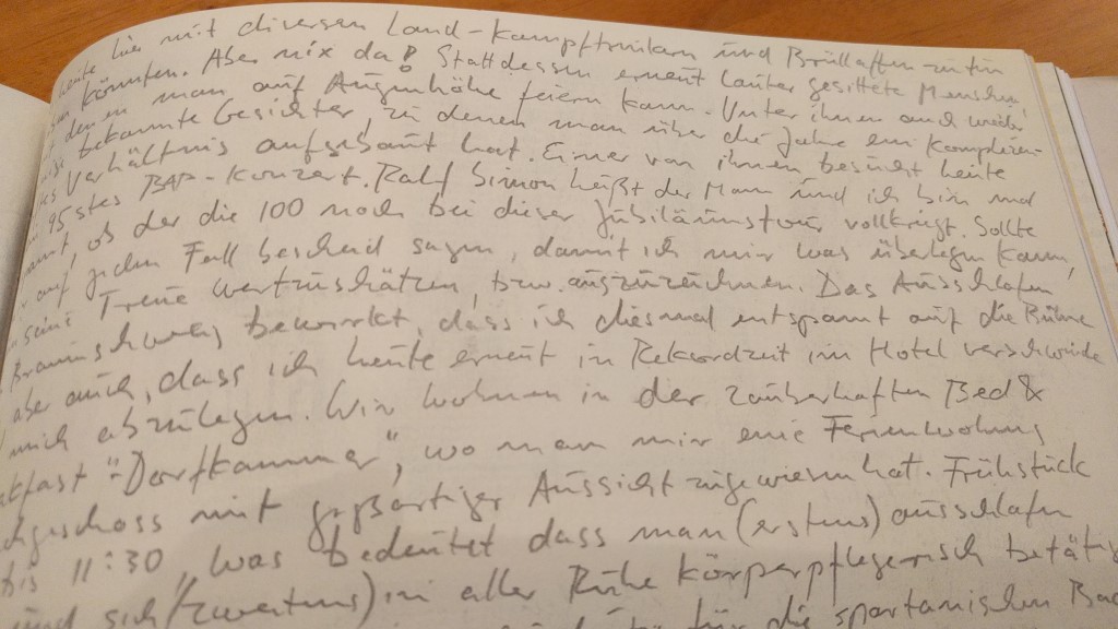 Eine handschriftliche Notiz in einem Notizbuch. Der Text ist in deutscher Sprache verfasst und enthält persönliche Erinnerungen und Details zu einem Treffen mit Ralf Simon.