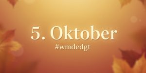Herbstlicher Hintergrund in warmen Orange-, Gelb- und Brauntönen mit unscharfen Ahornblättern. In der Bildmitte steht der Text "5. Oktober" in großer, weißer Schrift, darunter der Hashtag "#wmdedgt".